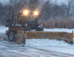 Snow plow clearing a commercial parking lot in Madison WI